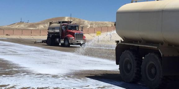 two trucks pouring substance